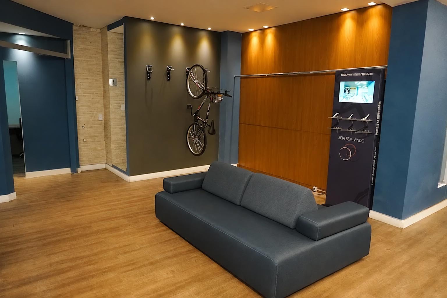 Recepção do espaço de atendimento com sofá e painel de madeira